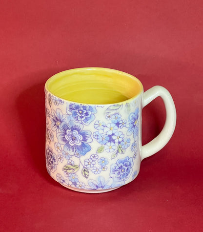 White porcelain mug with blue glazed floral motif. Yellow Liner Glaze.